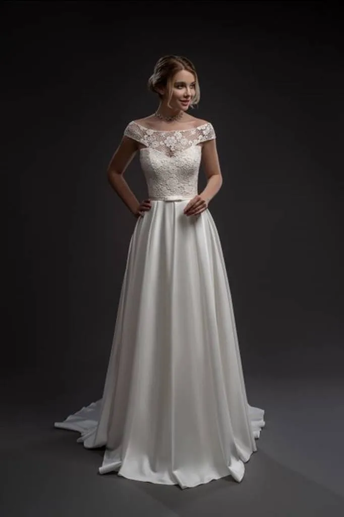 ---Elegant and tailored wedding dress with an unmistakable style in satin and lace with a bateau neckline and long rows of butto