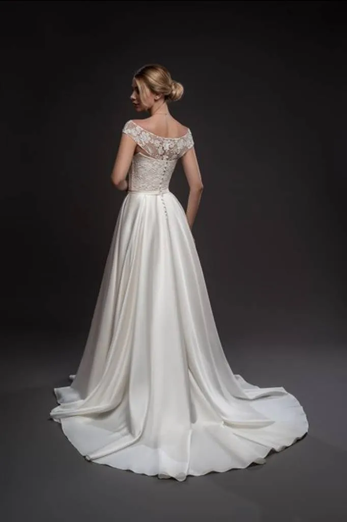 ---Elegant and tailored wedding dress with an unmistakable style in satin and lace with a bateau neckline and long rows of butto